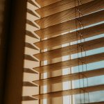 Sunlight filtering through wooden blinds creates a warm and calming atmosphere.